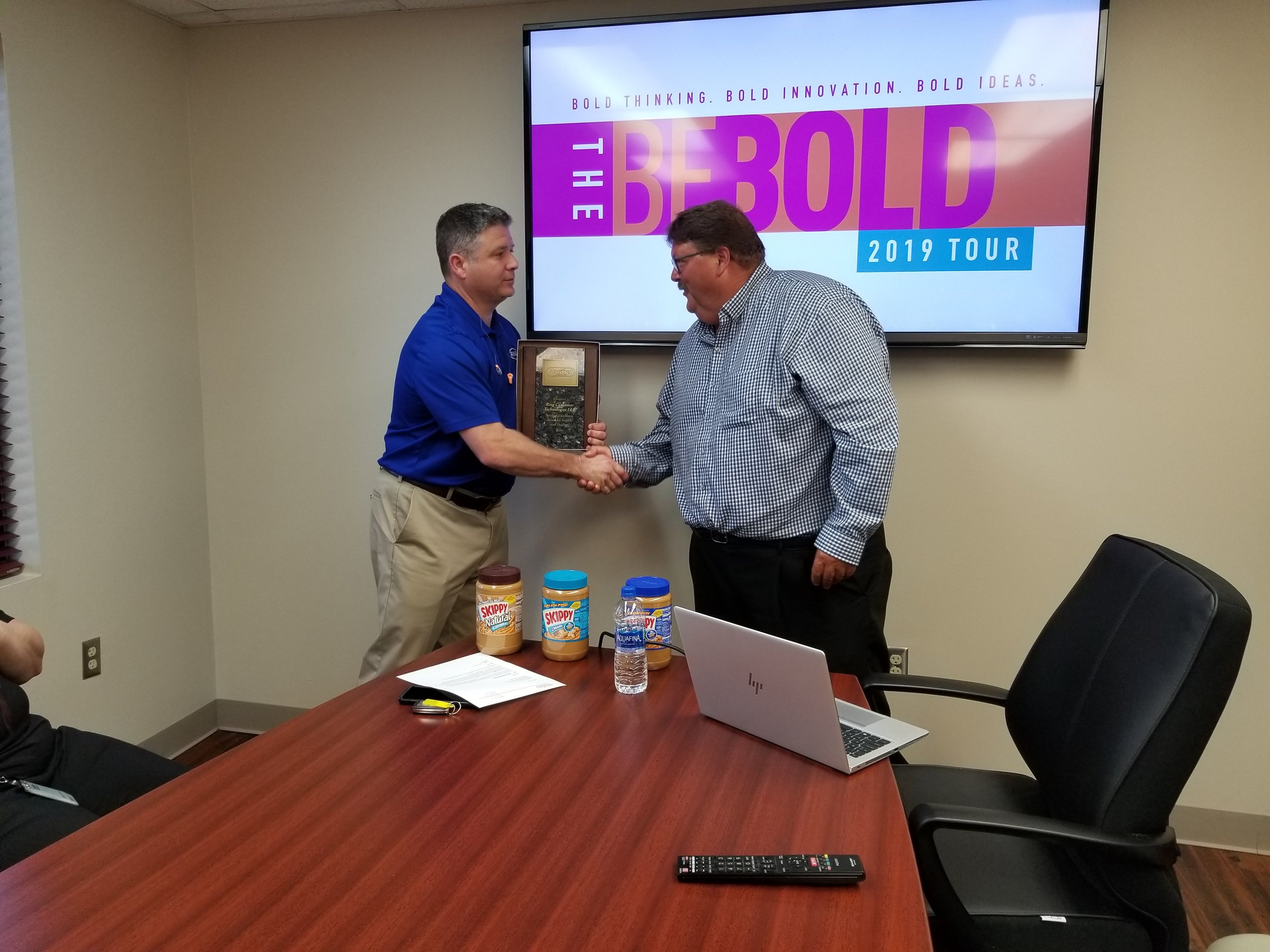 Ring Little Rock plant manager Ray Lovelace accepts the award from Bill Hacker, Hormel corporate buyer.